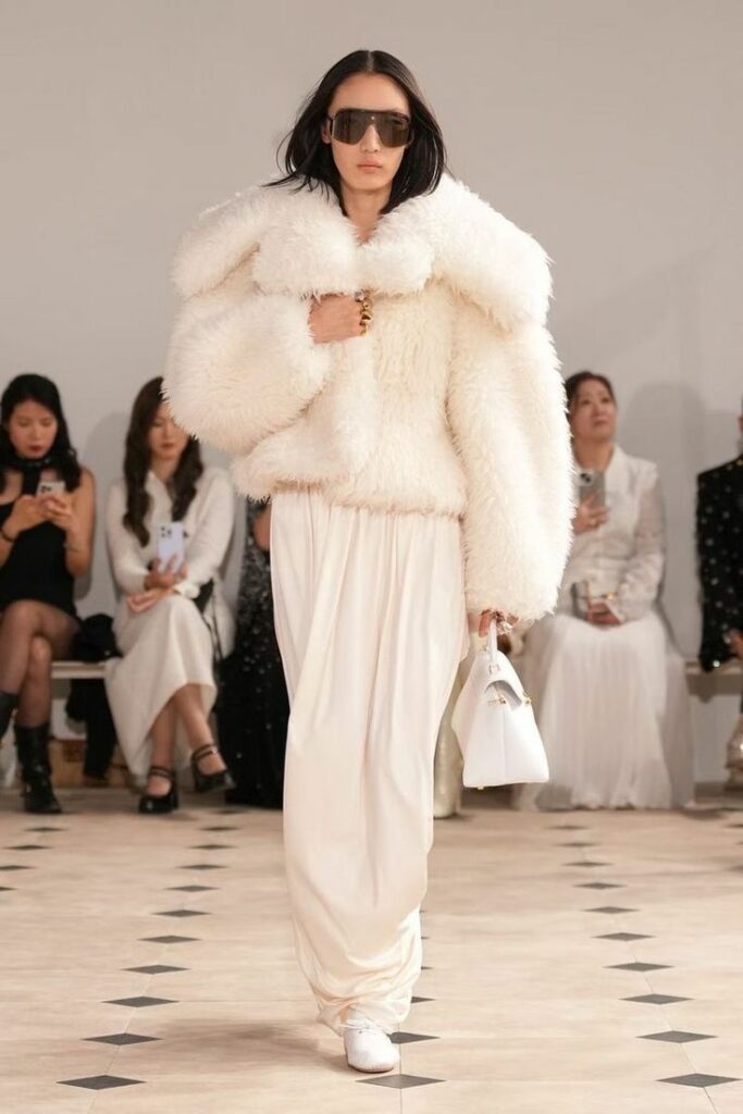 Model Xiru Yang goes down the catwalk during the Celine Spring/Summer 2026 ready-to-wear collection fashion show, wearing a faux fur jacket and a floor-length dress