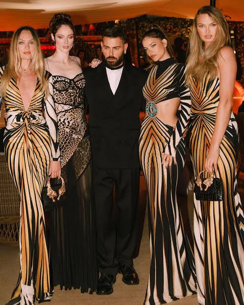 Dubai Fashion week, man with 4 models wearing fashionabler dresses 