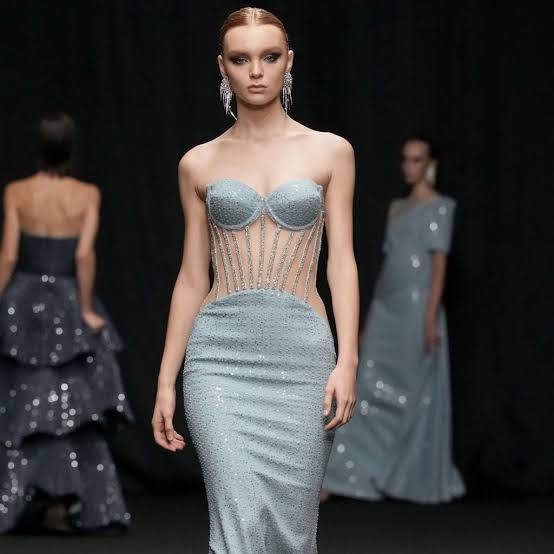 Model wearing light green dress with semi see through mid section 