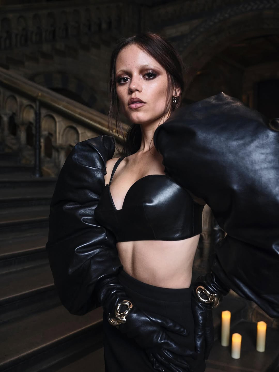 Her ensemble featured three-piece cocoon-shaped puffed leather gloves, a sleek bullet sweetheart neckline bra top, and a high-waisted “Kick Back” midi skirt