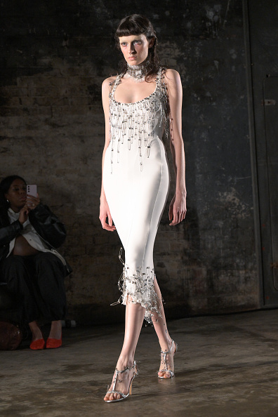 Dilara Findikoglu’s Fall 2025 ready-to-wear collection included the “Chloe as Venus” midi dress, made of soft cotton jersey and decorated with silver safety pins along the scoop neckline and hemline with distressed detailing.