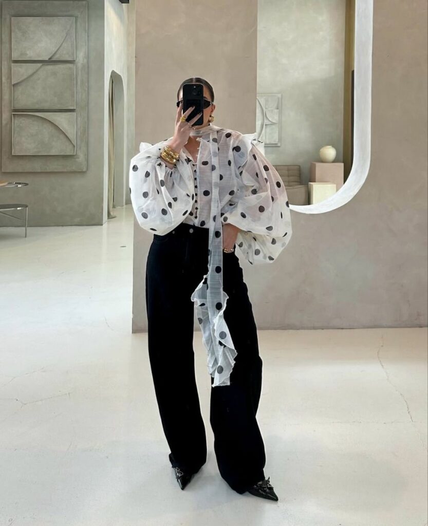 woman taking selfie wearinjg white shirt with blue pants vintage prep and polka dots