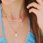model in blue top wearing waterproof jewelry necklaces