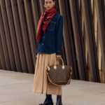 woman holding Louis Vuitton bags