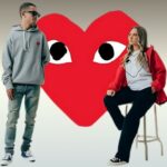 Male and female models in front of Syna world logo