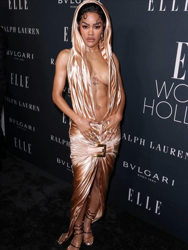 At ELLE’s 2025 Women in Hollywood, Teyana Taylor exudes sophistication in a breathtaking Balmain hooded gold gown, featuring a deep V-neck and exquisite ruching details.