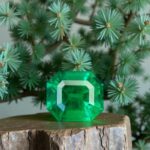 green emerald stone in front of evergreen
