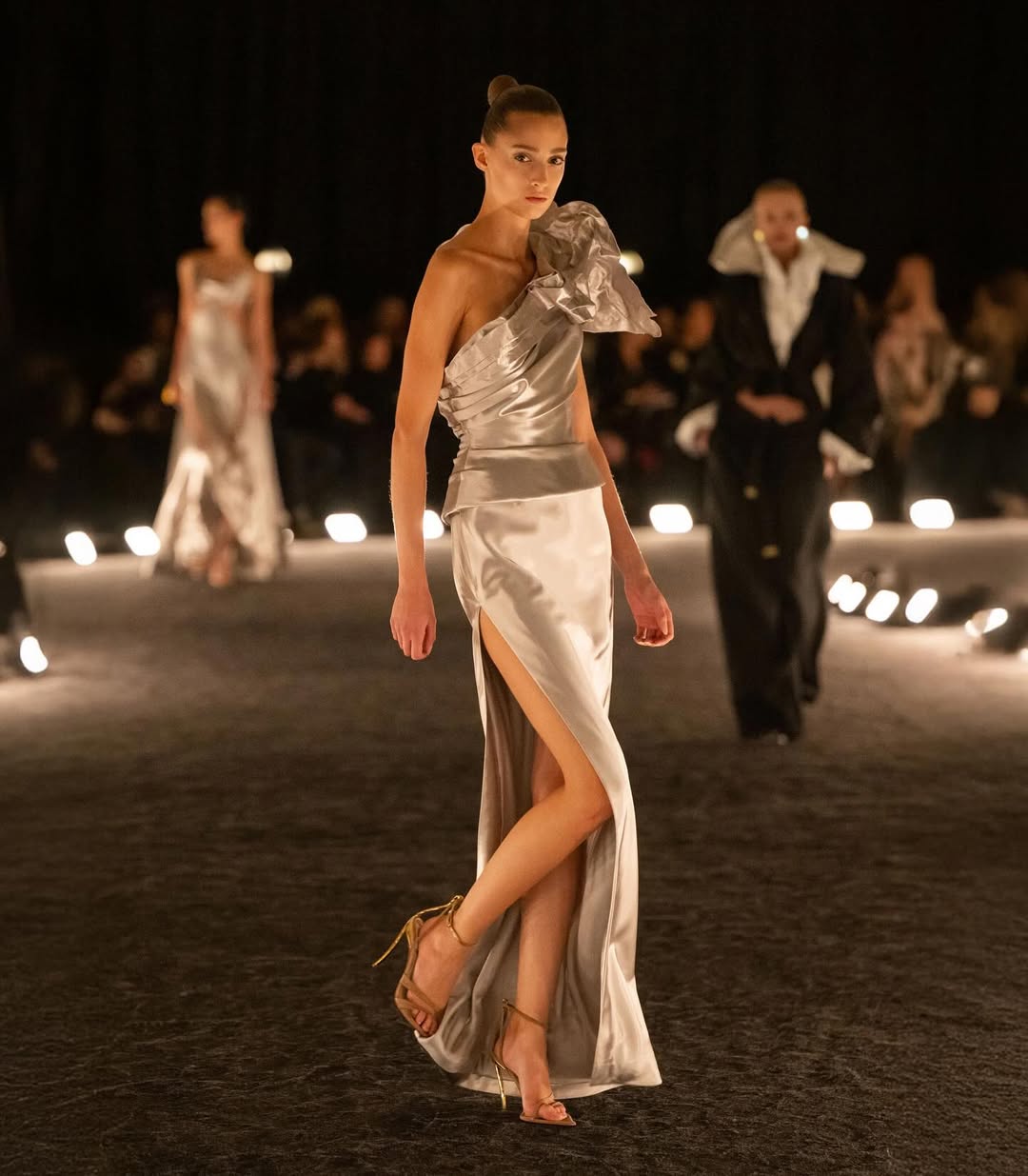 The Schiaparelli Womenswear Spring/Summer 2026 ready-to-wear collection features model Anasofia Negrutsa on the catwalk in a bias-cut gown.